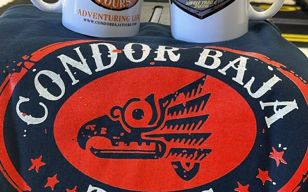 coffee cups and a t-shirt with Anita's memorial ride and Condor's logo, with a motorcycle in the background.